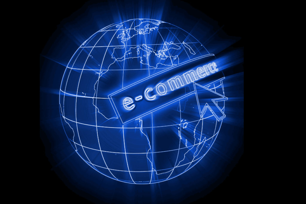 Dünya haritası üzerinde parlayan e-ticaret yazısı ve dijital ok simgesi