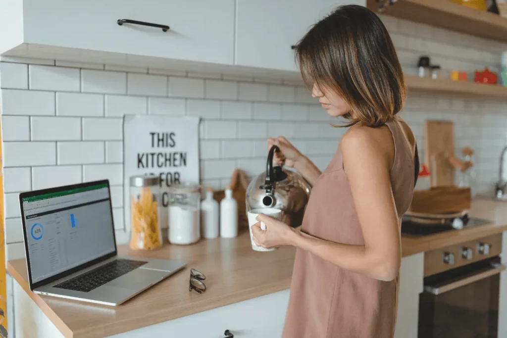 E-ticarette hikayeleştirme örneği: mutfakta kahve hazırlarken bilgisayarına bakan kadın