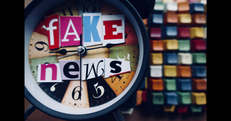 Üzerinde fake news yazan bir saat ve renkli tuşlar, Barnum Etkisi nedeniyle genel bilgilere inanma eğilimini simgeliyor.